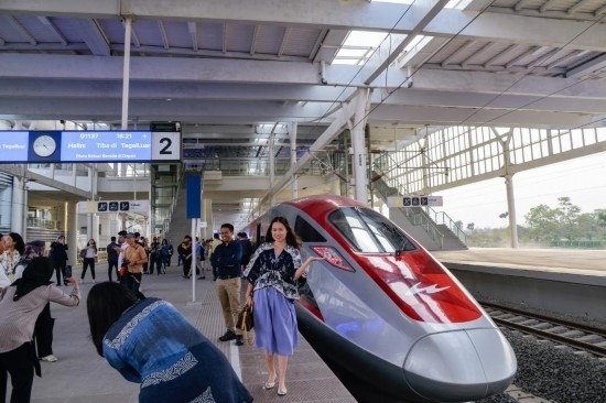  10月17日，在印度尼西亞萬隆德卡魯爾站，乘客在站臺上和雅萬高鐵高速動車組列車合影。新華社記者 徐欽 攝