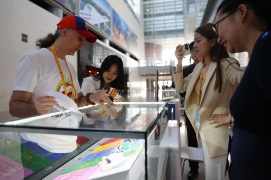 10月16日，參會(huì)記者在“一帶一路”國(guó)際合作高峰論壇新聞中心參觀展示的中國(guó)非物質(zhì)文化遺產(chǎn)展品。新華社記者 陳斌 攝