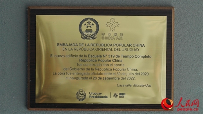 小學(xué)墻上懸掛的中國援助標(biāo)識(shí)。人民網(wǎng)記者 張若涵攝