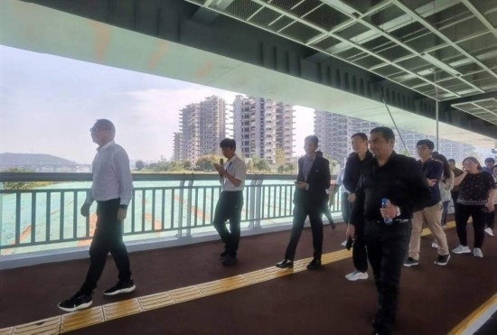 10月24日，2023“一帶一路”媒體合作論壇聯(lián)合采訪團(tuán)團(tuán)員走在清水塘大橋景觀通道上。本報(bào)記者 常雯宜攝