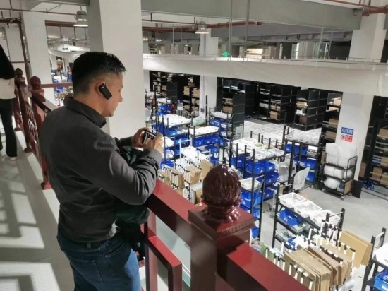 2023“一帶一路”媒體合作論壇聯(lián)合采訪團(tuán)團(tuán)員在仁和醫(yī)藥物流園拍攝記錄轉(zhuǎn)運(yùn)流程。（本報(bào)記者 黃超攝）