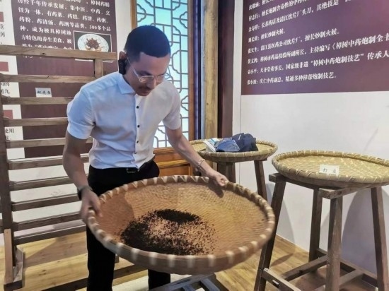 2023“一帶一路”媒體合作論壇聯(lián)合采訪團(tuán)團(tuán)員在非遺文化展示館體驗(yàn)中藥炮制技藝。（本報(bào)記者 黃超攝）