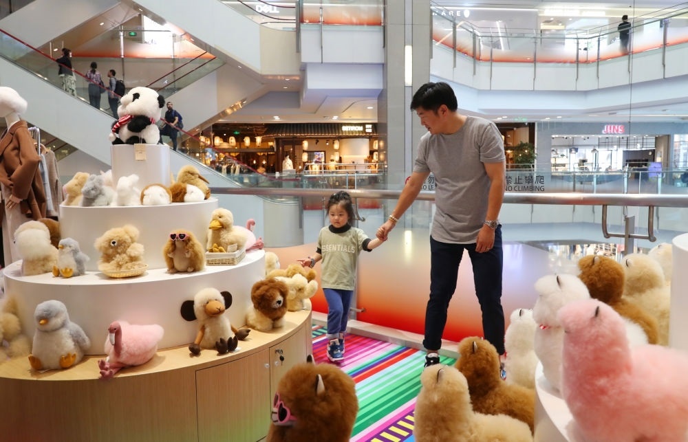 2023年11月2日，顧客在溫暖駝品牌專柜內(nèi)選購。連續(xù)六年參加進(jìn)博會(huì)的秘魯羊駝制品品牌溫暖駝在上海市中心商場開設(shè)了專柜。新華社記者 方喆 攝