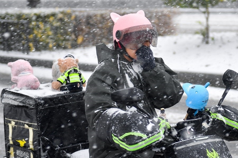 11月6日，在長春市街頭，一名外賣員在雪中騎行。新華社記者 許暢 攝