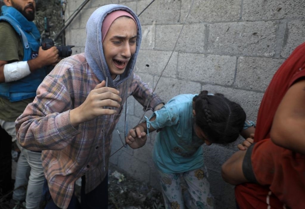 11月6日，人們從加沙地帶中部地區(qū)一處被炸難民營逃離。新華社發(fā)（亞西爾·庫迪攝）