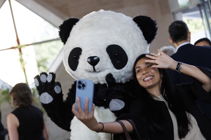 2022年8月24日，在美國華盛頓中國駐美國大使館，來賓與大熊貓玩偶合影。