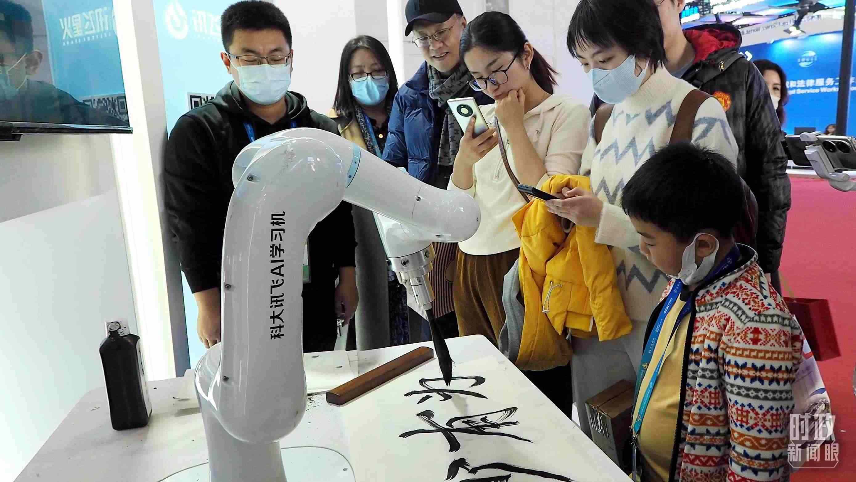 △觀眾在首屆鏈博會(huì)上體驗(yàn)AI書法機(jī)器人。