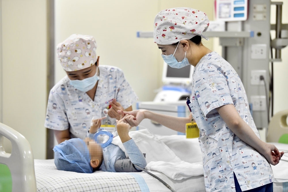 在山東省棗莊市婦幼保健院兒童ICU病房，醫(yī)護(hù)人員為完成靶向治療藥物諾西那生鈉的4歲脊髓性肌萎縮癥患兒加油鼓勁（2022年1月1日攝）。諾西那生鈉注射液是我國(guó)首個(gè)獲批治療脊髓性肌萎縮癥的進(jìn)口藥物，2019年進(jìn)入中國(guó)市場(chǎng)時(shí)，每針價(jià)格近70萬(wàn)元。在2021年國(guó)家醫(yī)保目錄藥品談判中，以3.3萬(wàn)元每針的價(jià)格進(jìn)入新版醫(yī)保藥品目錄。新華社記者 郭緒雷 攝