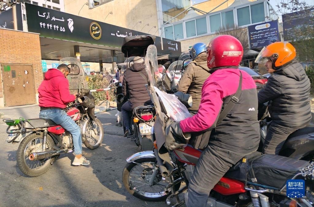 12月18日，摩托車在伊朗首都德黑蘭的一家加油站外等待加油。新華社記者 沙達(dá)提 攝