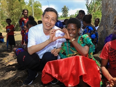 2023年12月18日，中國駐瓦努阿圖大使李名剛和前來觀看瓦努阿圖公路項目二期馬勒庫拉段移交儀式的當?shù)鼐用窈嫌?。人民網(wǎng) 賀吉攝