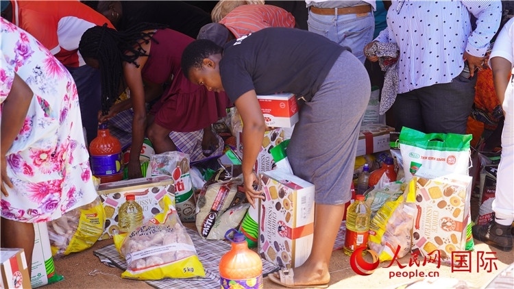 當(dāng)?shù)厣鐓^(qū)家庭領(lǐng)取物資。人民網(wǎng) 張茜攝