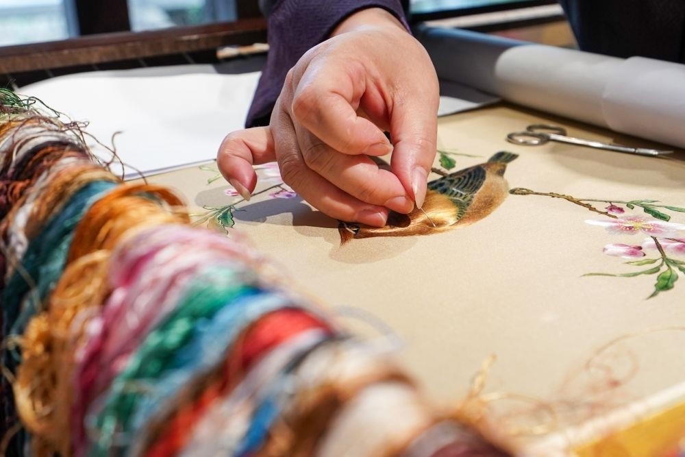 △2023年7月6日，盧建英在江蘇蘇州平江路的工作室內(nèi)刺繡。