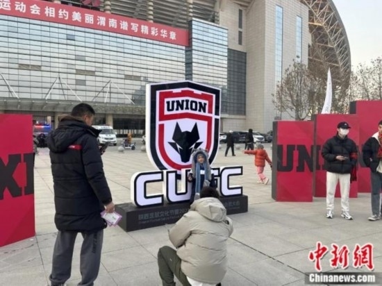 球迷們與隊(duì)徽合影。記者 卞立群 攝