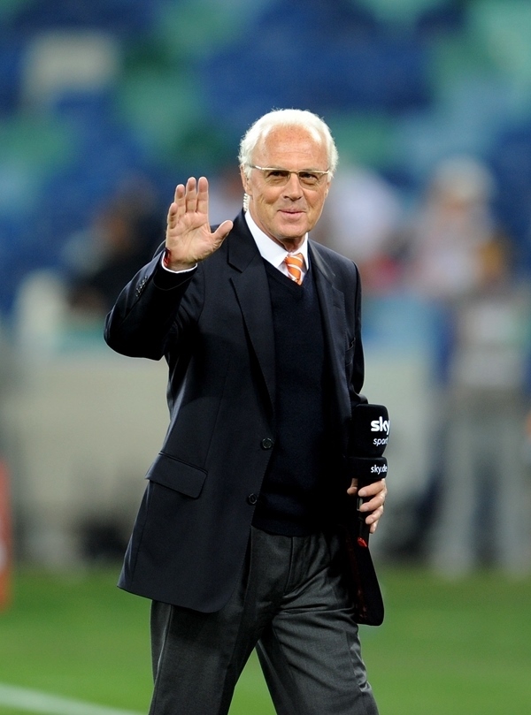 這是2010年7月7日，在南非德班舉行的2010年足球世界杯德國隊(duì)對陣西班牙隊(duì)的半決賽前，貝肯鮑爾接受電視臺采訪時(shí)和友人打招呼。新華社記者 王毓國 攝