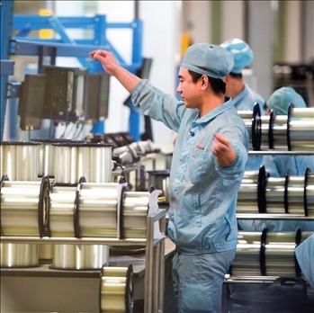 在位于武漢的長飛光纖光纜股份有限公司光纖生產(chǎn)車間內(nèi)，工作人員對光纖進行檢測（資料圖片）。肖藝九攝/本刊