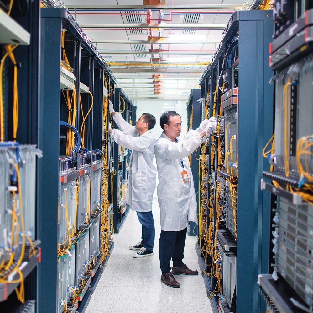 在位于武漢中國光谷的光電器件研發(fā)制造商——武漢光迅科技股份有限公司生產(chǎn)車間內(nèi)，技術(shù)人員在光模塊生產(chǎn)線作業(yè)（2023年4月11日攝）。程敏攝/本刊