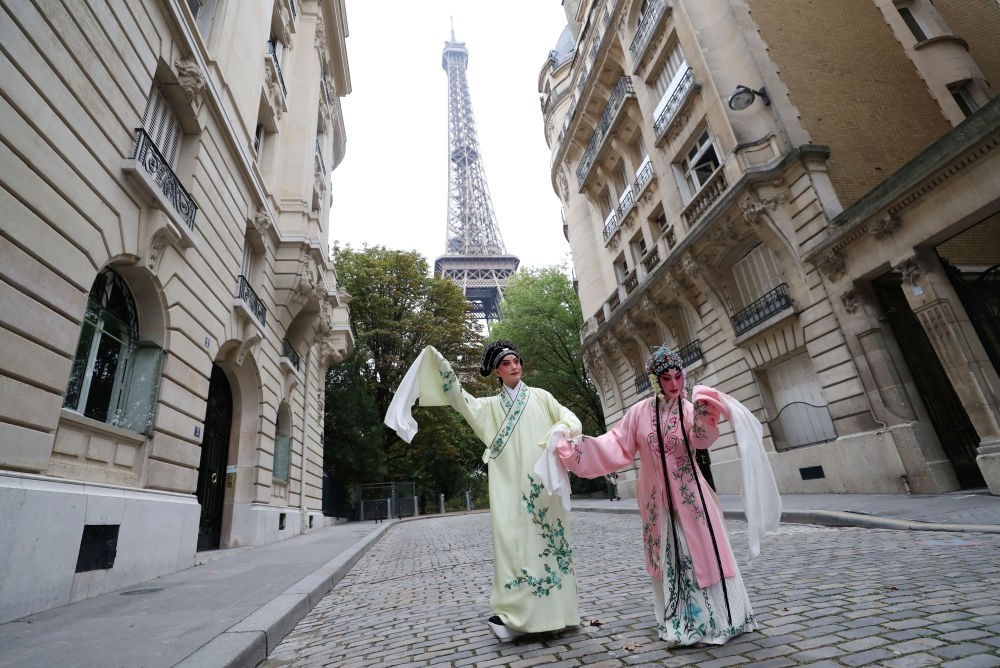 2023年9月13日，江蘇省演藝集團(tuán)昆劇院院長(zhǎng)施夏明（左）和江蘇省演藝集團(tuán)昆劇院國(guó)家一級(jí)演員孔愛萍在法國(guó)巴黎埃菲爾鐵塔附近參加昆曲快閃。新華社記者 高靜 攝