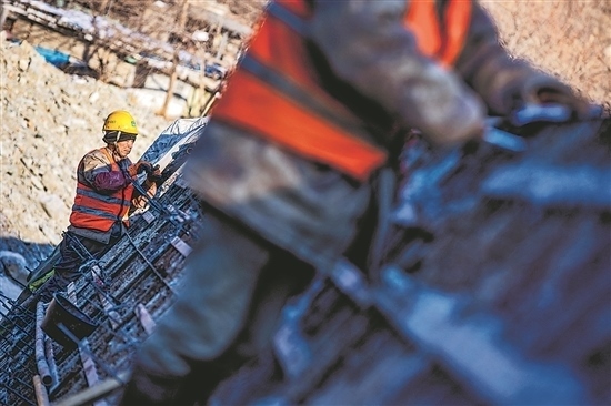 1月3日，房山區(qū)，工人正在雙泉河修筑堤壩。