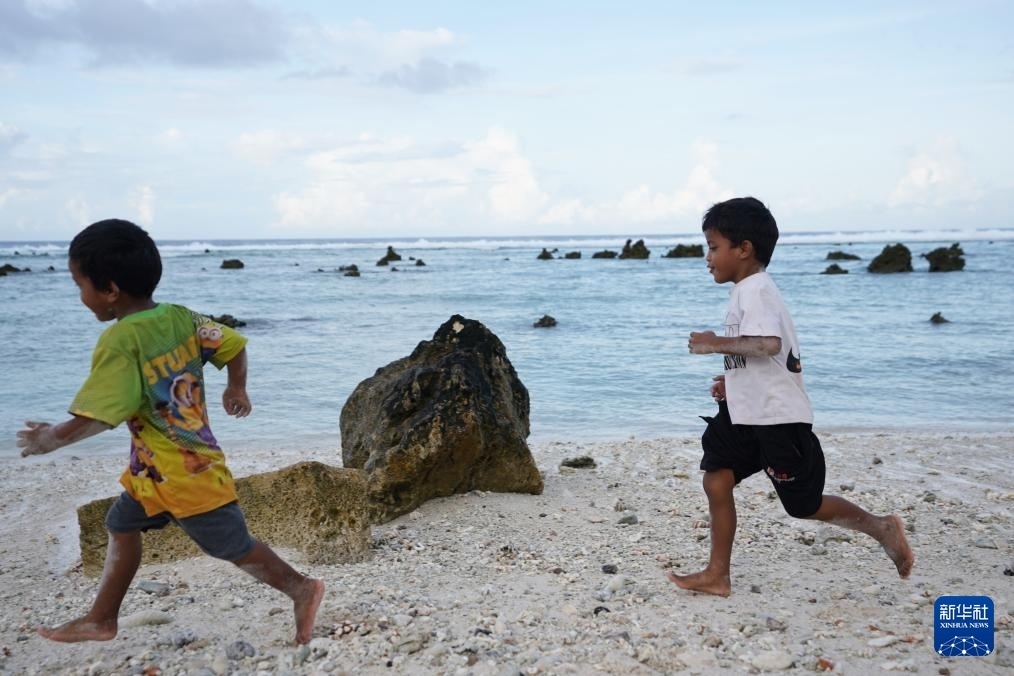 1月20日，兒童在瑙魯海邊嬉戲。新華社記者 王申 攝