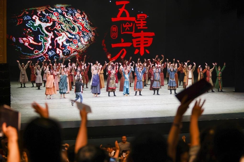 2023年7月31日，新疆和田地區(qū)新玉歌舞團(tuán)在烏魯木齊京劇院演出舞劇《五星出東方》后和觀眾互相揮手致意。這場演出是第六屆中國新疆國際民族舞蹈節(jié)的參演劇目之一，曾榮獲國家“文華獎(jiǎng)”等。新華社記者 郝昭 攝