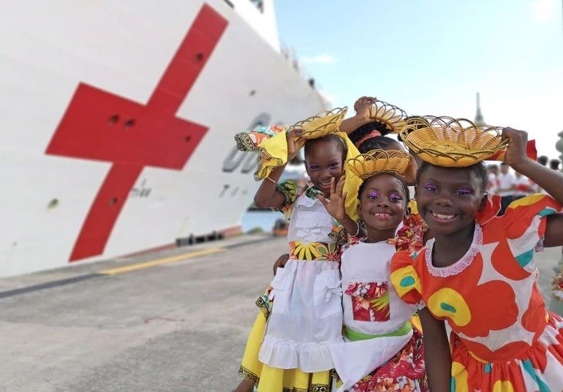 2018年10月，在安提瓜和巴布達首都圣約翰，當?shù)匦∨笥焉泶﹤鹘y(tǒng)服裝歡迎中國海軍“和平方舟”醫(yī)院船首次到訪。