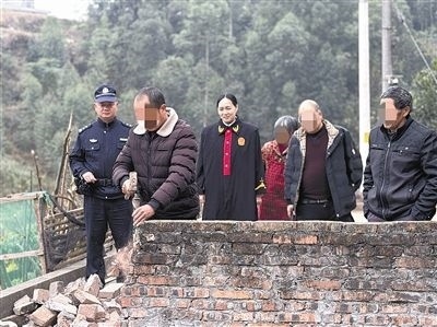  圖③：庭審結束后，在法官的見證下，陳某在院壩邊重新開鑿一條通道。