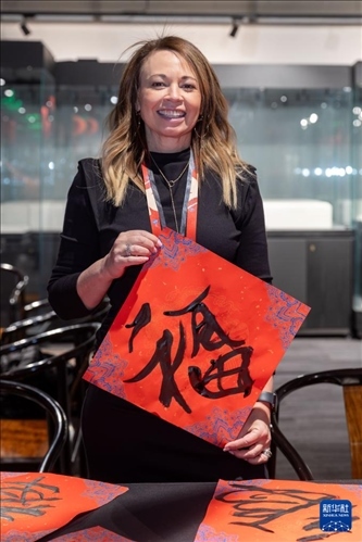 1月28日，在上海豫園舉行的民俗活動上，美國馬斯卡廷初中校長珍妮弗·李·弗里德利展示自己寫下的“?！弊?。 新華社記者 王翔 攝