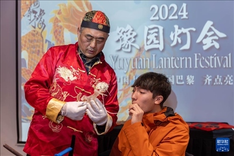 1月28日，在上海豫園舉行的民俗活動上，美國馬斯卡廷中學(xué)學(xué)生在非遺傳承人的指導(dǎo)下吹糖偶。 新華社記者 王翔 攝