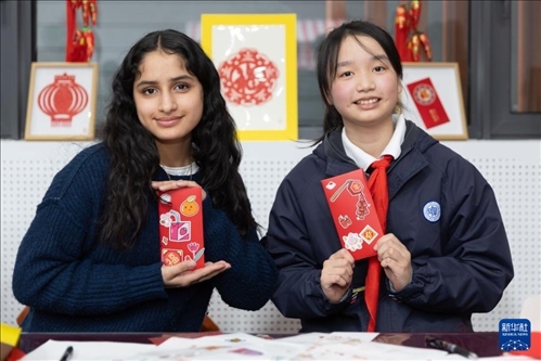 1月28日，美國馬斯卡廷中學(xué)學(xué)生（左）和復(fù)旦大學(xué)第二附屬學(xué)校學(xué)生展示互相送出的寫有寄語祝福的紅包。 新華社記者 王翔 攝