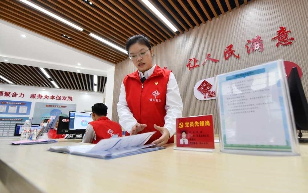 △2023年12月14日，廣西南寧市蟠龍社區(qū)，工作人員在為居民服務(wù)。