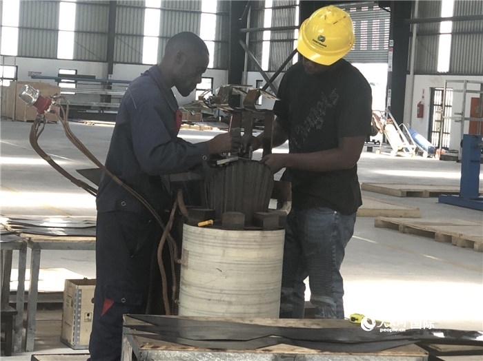 經(jīng)貿(mào)合作區(qū)廠房內(nèi)，當(dāng)?shù)毓と苏诰o張作業(yè)。人民網(wǎng)記者 黃培昭攝