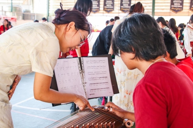 志愿者教師指導(dǎo)學(xué)生彈奏古箏?；顒?dòng)主辦方供圖