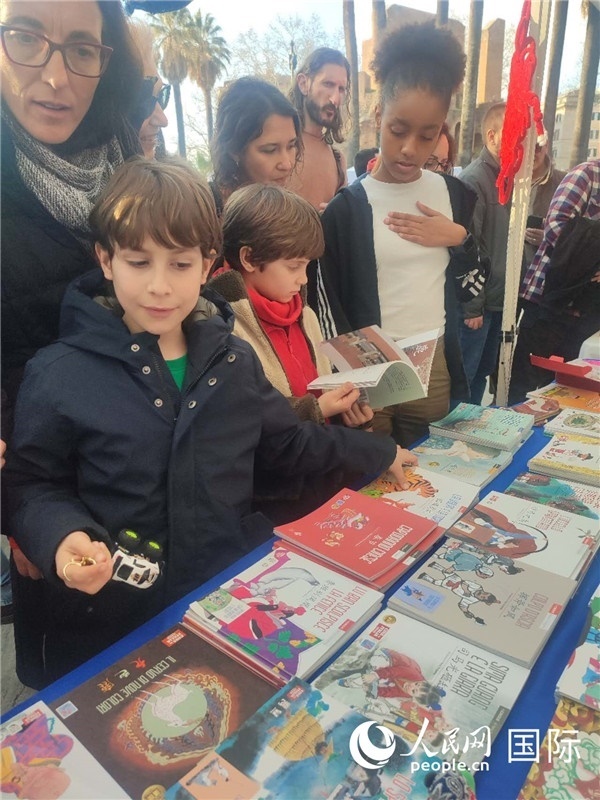 印刷精美的中國傳統(tǒng)文化叢書吸引了小游客的注意。人民網(wǎng)記者鄭彬攝