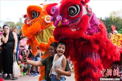 圖為舞獅表演吸引民眾合影。張興龍攝