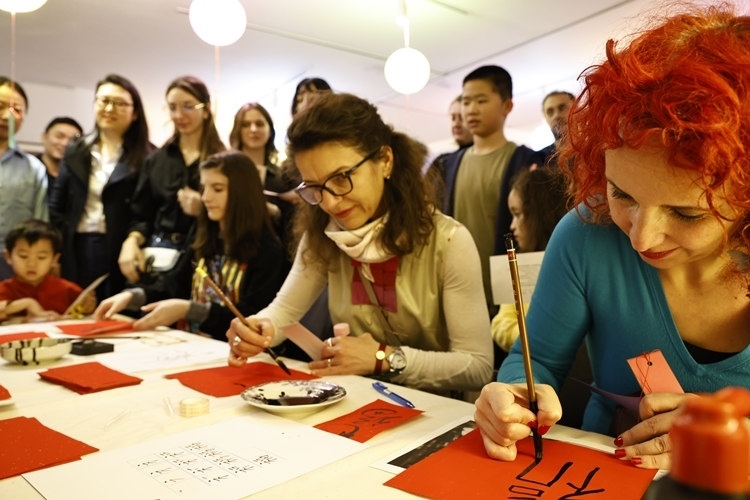 羅馬尼亞觀眾學(xué)習(xí)用毛筆寫“?！弊?。中國(guó)文化中心供圖