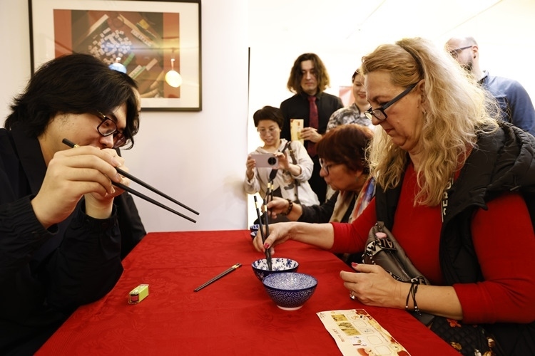 羅馬尼亞觀眾體驗(yàn)用筷子夾花生。中國(guó)文化中心供圖