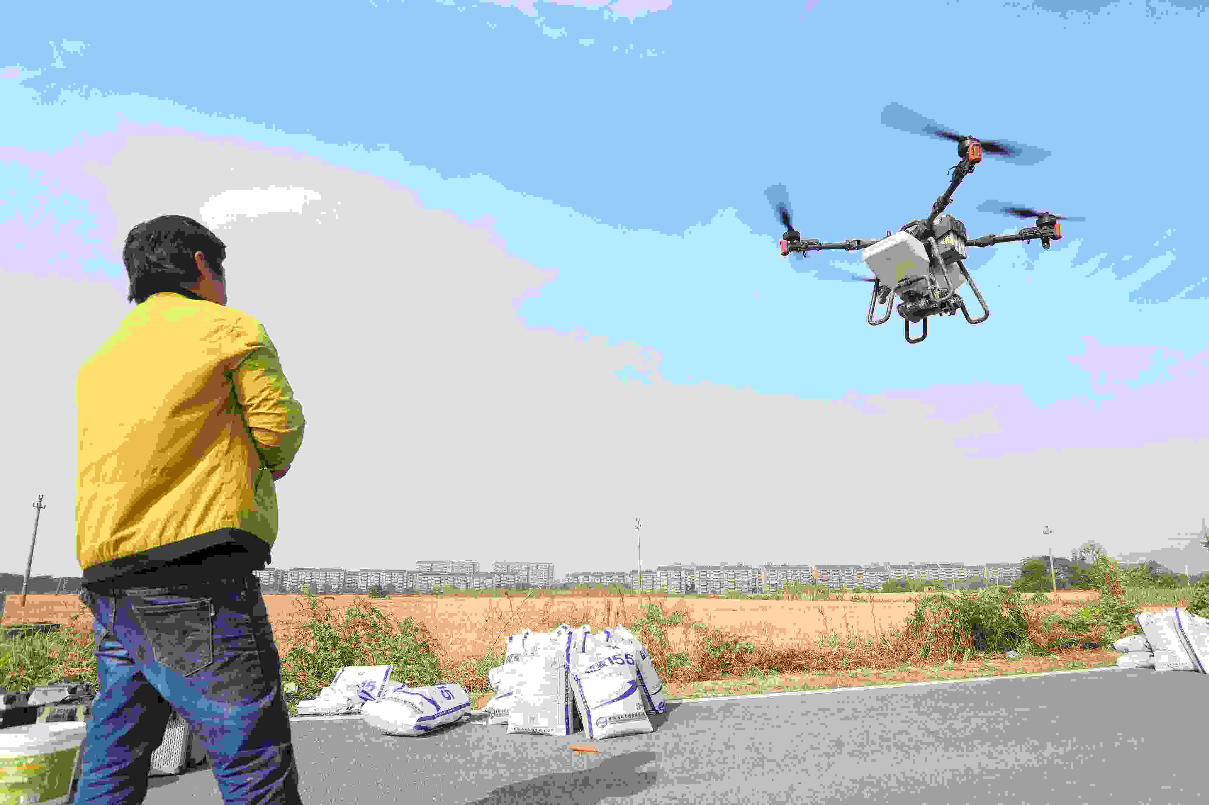 2023年11月15日，浙江嘉興，南湖區(qū)七星街道一處農(nóng)田里，農(nóng)民操縱無人機進行冬小麥飛播。