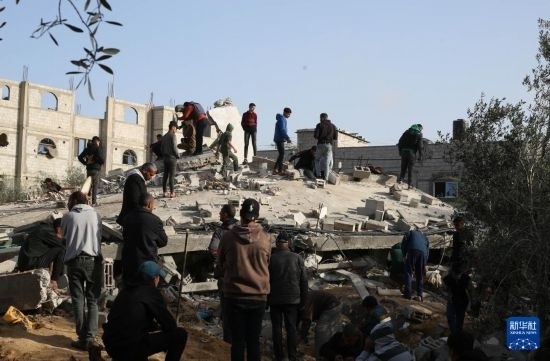  3月3日，在加沙地帶南部城市拉法，人們查看被以軍空襲破壞的建筑。新華社發(fā)（哈立德·奧馬爾攝）