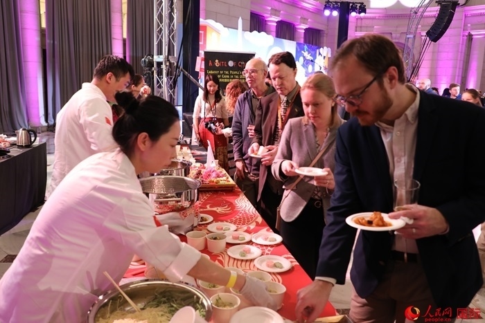 當(dāng)?shù)貢r(shí)間3月7日晚，華盛頓聯(lián)合車(chē)站廣場(chǎng)舉行駐美使團(tuán)“使館主廚挑戰(zhàn)賽”。圖為當(dāng)?shù)孛癖娫谥袊?guó)展臺(tái)前體驗(yàn)中國(guó)美食。人民網(wǎng)記者 李志偉攝