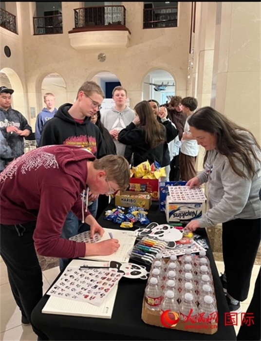 學(xué)生們出發(fā)前紛紛在留言簿留言。人民網(wǎng)記者 鄧圩攝