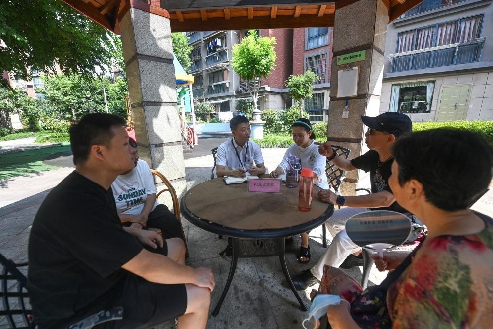 △2023年7月21日，在位于浙江杭州臨安區(qū)錦南街道水岸陽光小區(qū)的陽光議事廳，街道干部在聽取居民們反映的問題及意見。