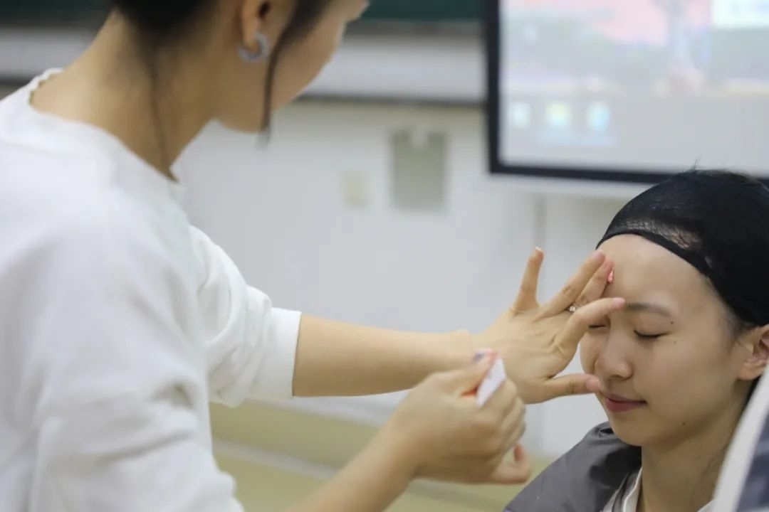 課堂上，一名學(xué)生在體驗上戲妝。學(xué)校供圖