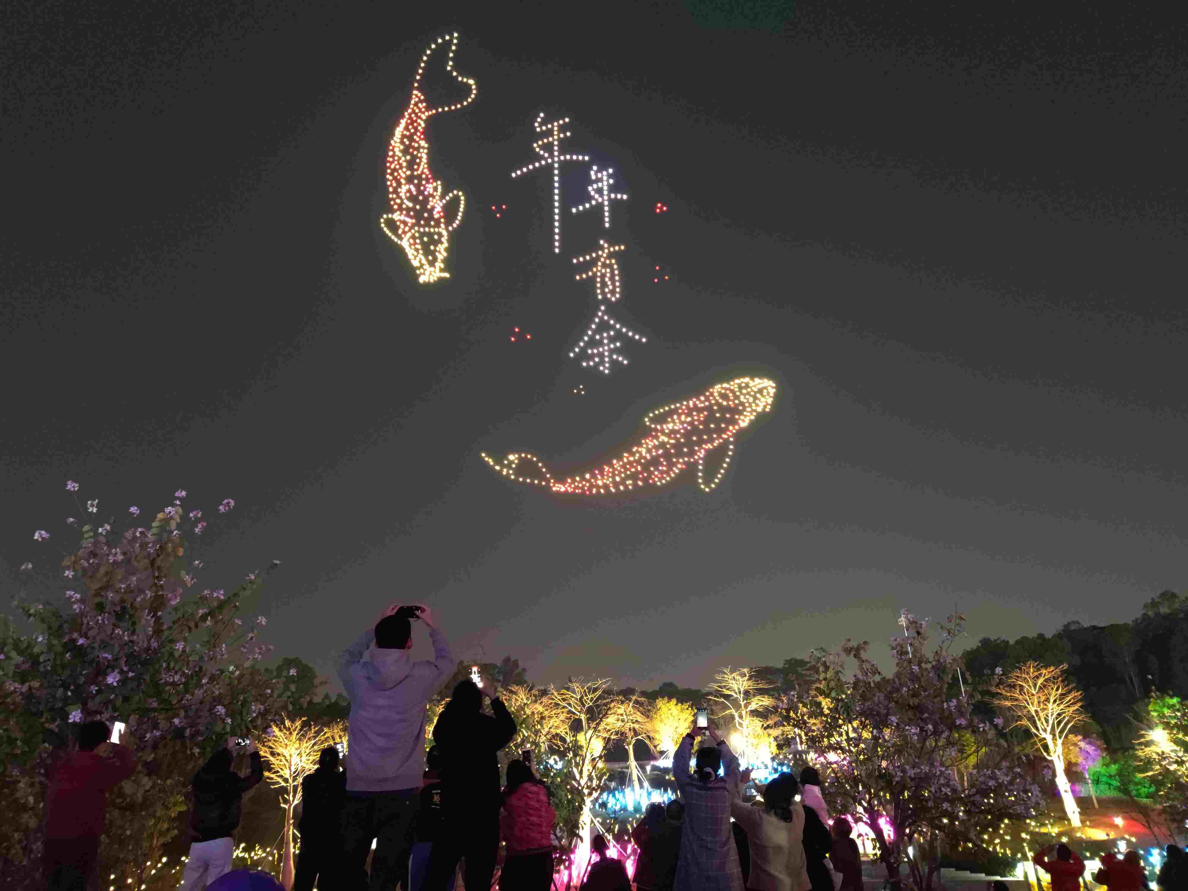△ 2024年2月10日，深圳北站中心公園，春節(jié)主題無人機(jī)燈光秀引來眾多游客駐足觀看。