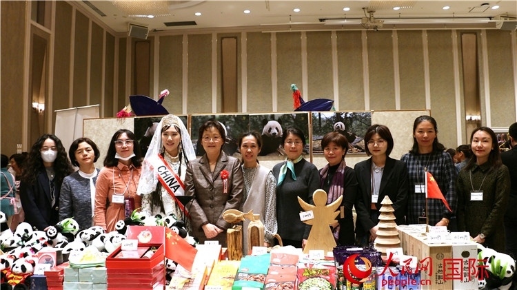 中國駐日本大使吳江浩夫人丁玥（左五）與使館人員在展位前合影留念。人民網 許可攝