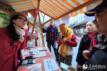 1月6日，“2024成都蒲江柑甜采摘節(jié)”上，記者見(jiàn)到了小萌（左一）和許多年輕人忙著做訪客接待、現(xiàn)場(chǎng)布置、票務(wù)核對(duì)、采摘服務(wù)等工作。人民網(wǎng)記者朱虹攝