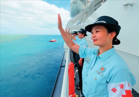 中國海軍“和平方舟”號醫(yī)院船結束訪問湯加時，任務官兵中的文職人員向歡送人群揮手告別（2023年8月4日攝）。徐巍攝/本刊