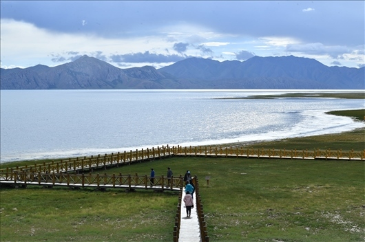 △ 游客行走在青?，敹嗫h冬格措納湖畔的木棧道上。