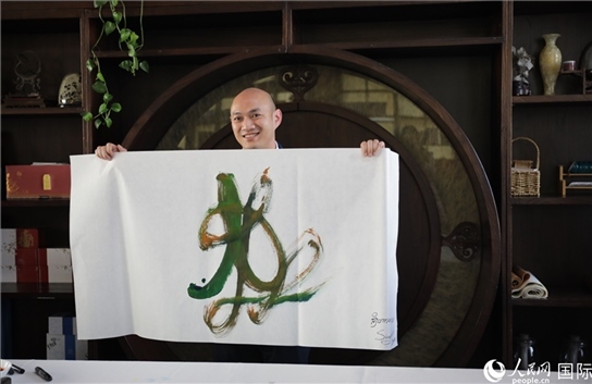 老撾駐華大使館三秘明君參加《五百筆·瀾湄合作》集體藝術創(chuàng)作。人民網(wǎng)王婧攝。