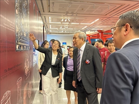 工作人員為泰國前副總理、泰中文化促進委員會主席披尼講解展覽內容。中國駐泰國大使館供圖