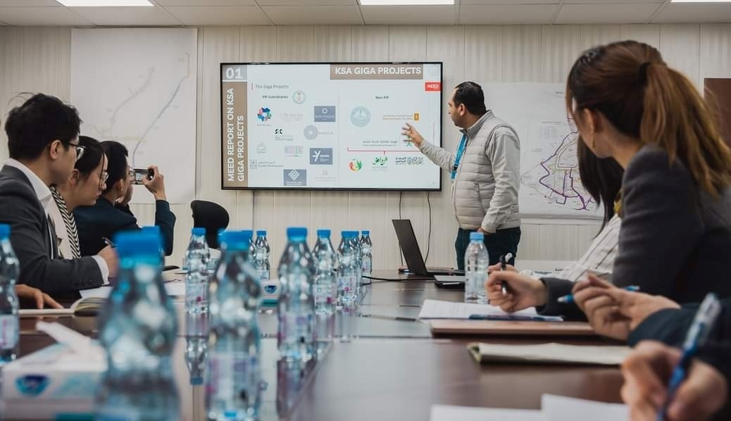 德亞（右三）在和員工開會。中建中東沙特分公司供圖